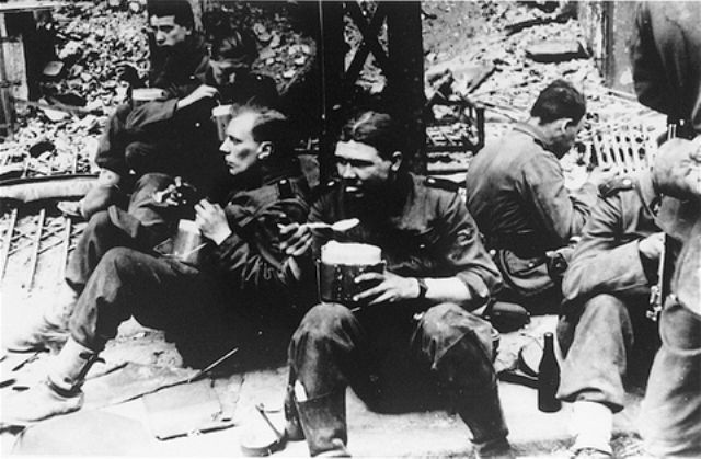 SS soldiers pause to eat during the suppression of the Warsaw ghetto uprising